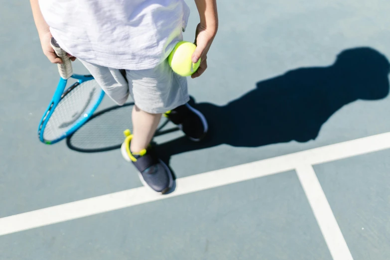 a person holding tennis racquets on top of a tennis court