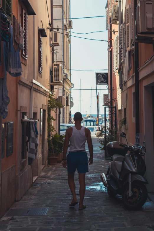 the person is walking down the narrow alleyway