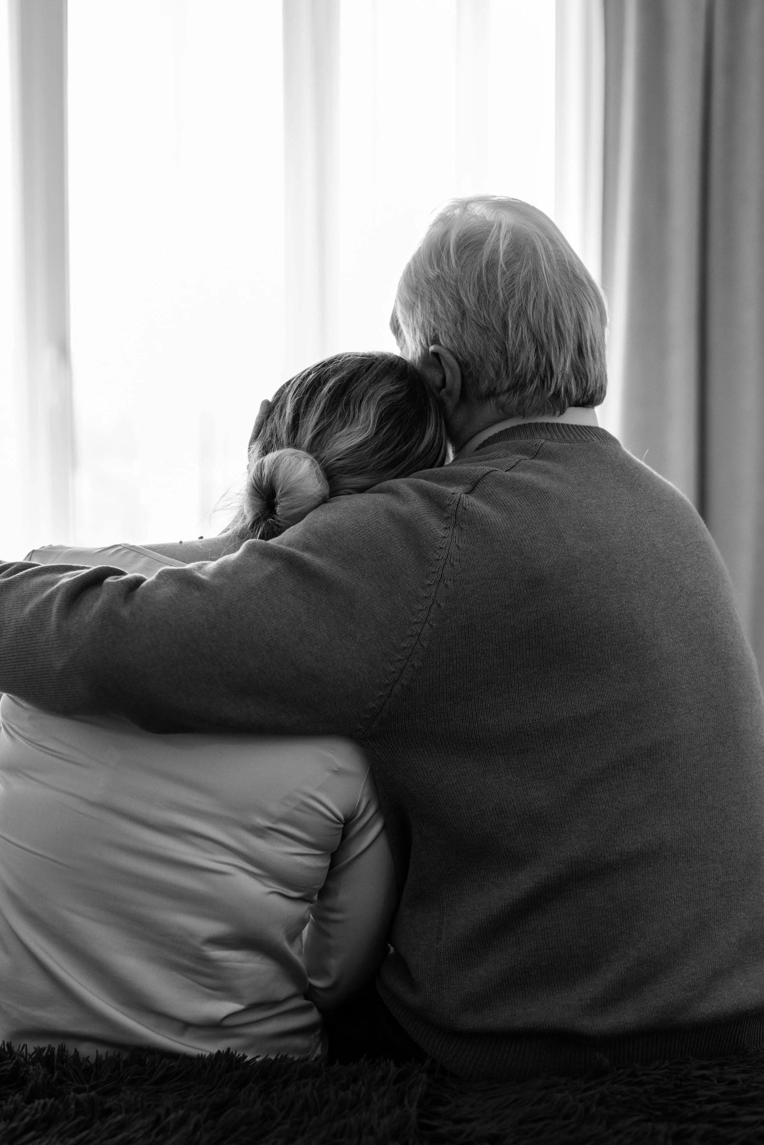 an old couple is sitting down on the bed