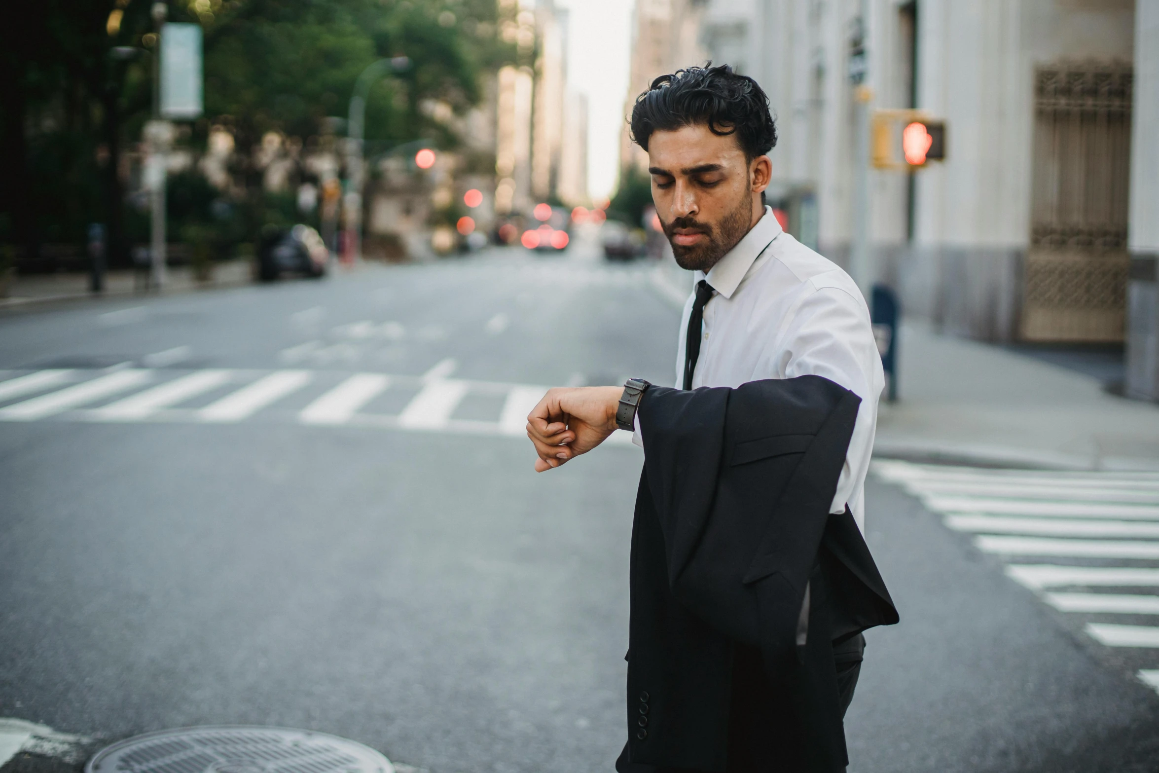 man in suit standing at the side of street looking away