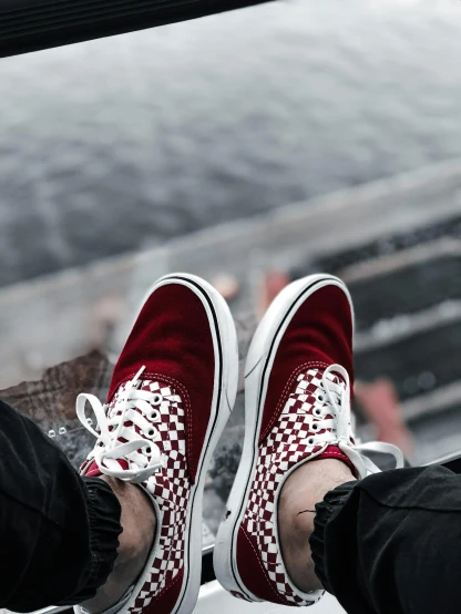 a person is in a red and white checkered tennis shoe