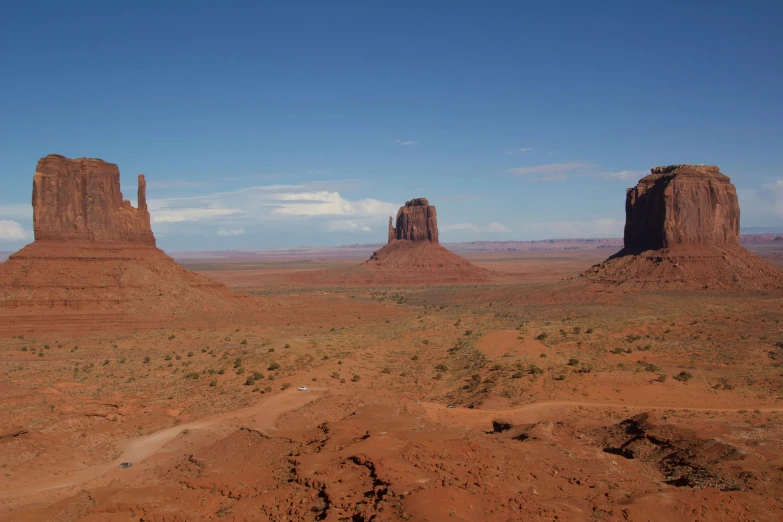 some very large mountains in the desert with a sky background