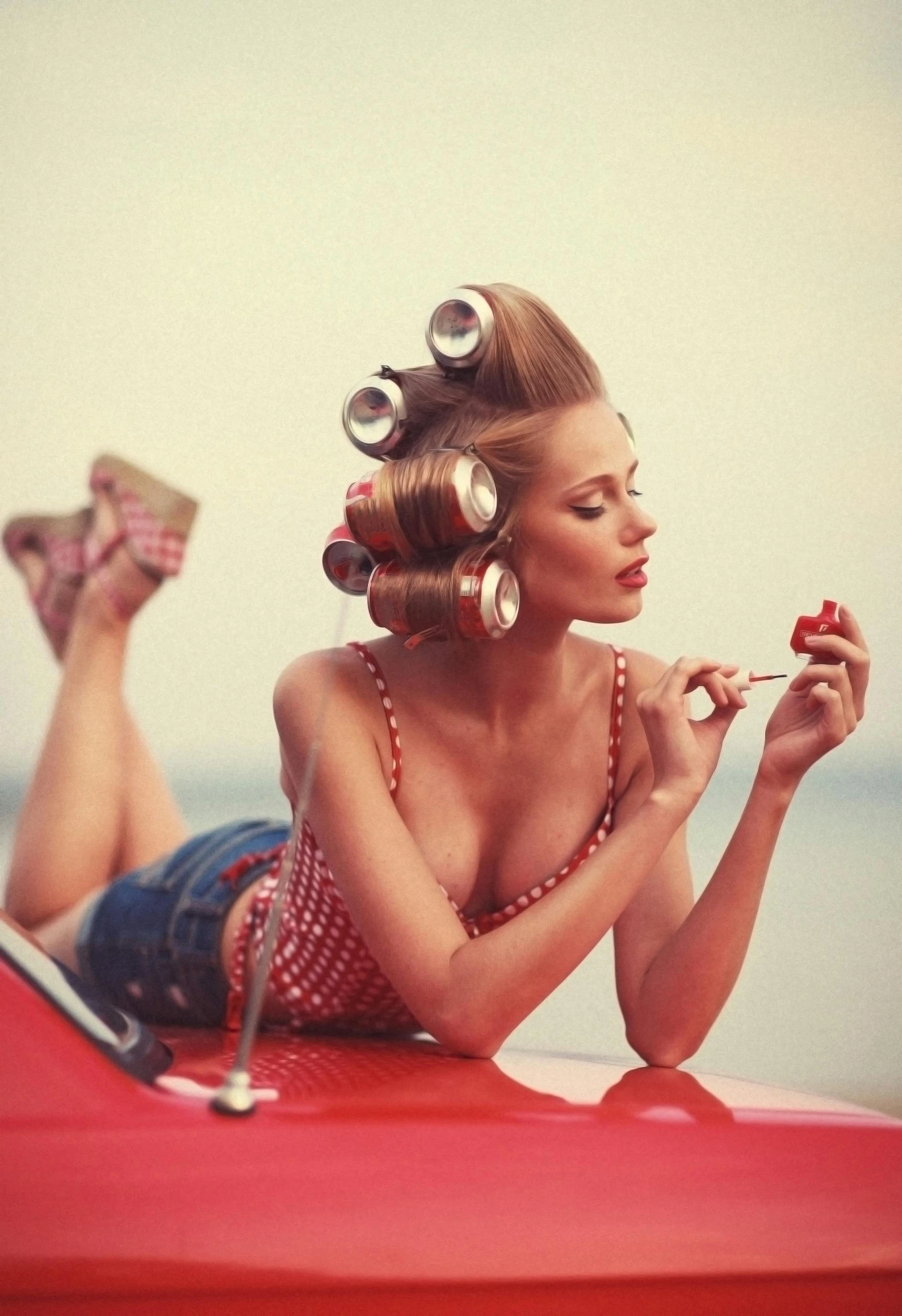 woman with hair rollers sitting on top of car