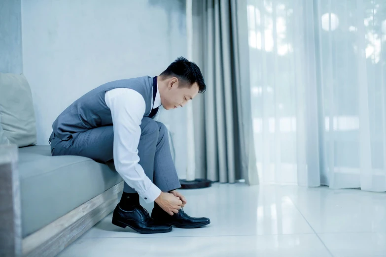 man crouches down to get ready to wear a dress