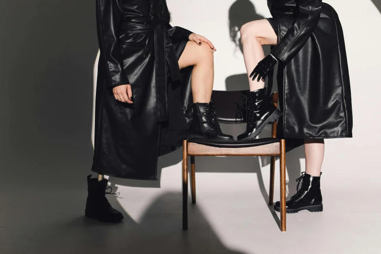two woman wearing boots and black dresses on the cover of a magazine