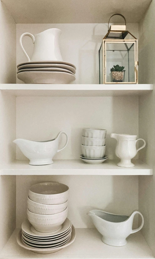 white dishes are stacked neatly on shelves