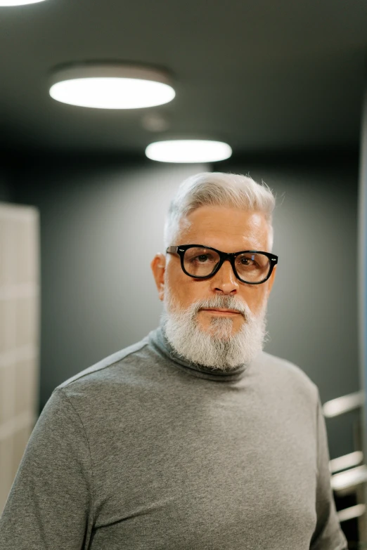 an older man with glasses and beard in a restroom