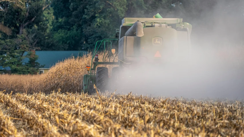 a combine is moving in a field full of golden hay