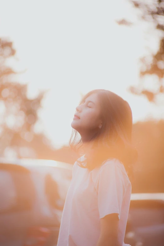 a woman stands outside in the sunlight