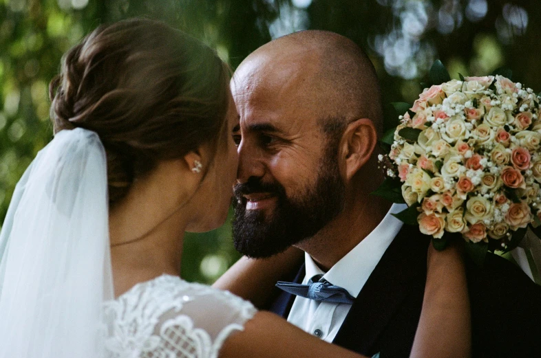 a bride and groom emce under some flowers