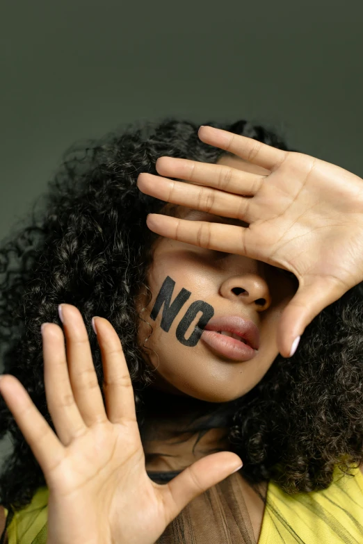 a woman with her hands on her head, and the word no written on her face