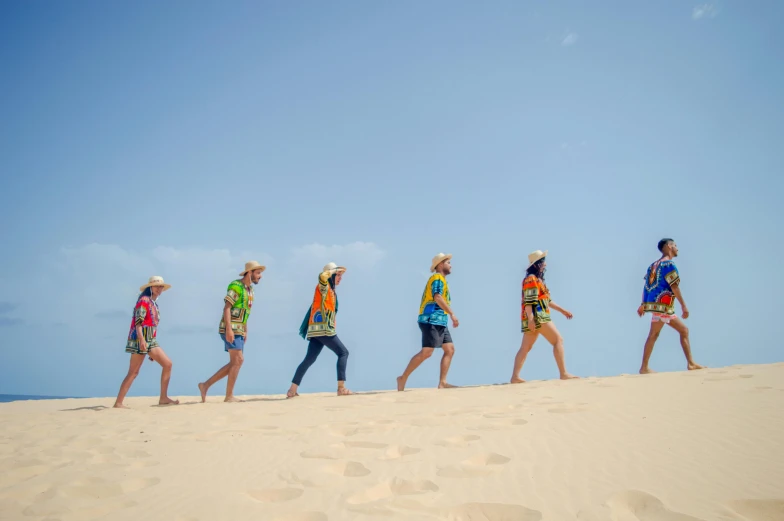 four people walk along the sand in front of them