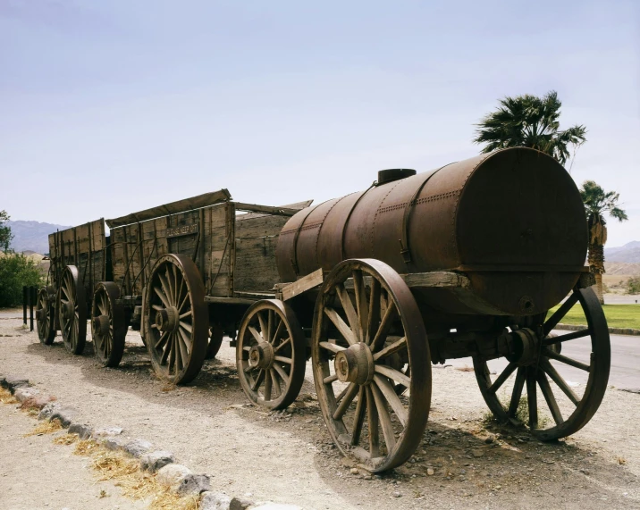 a wagon being moved by two wagon horses on a gravel road