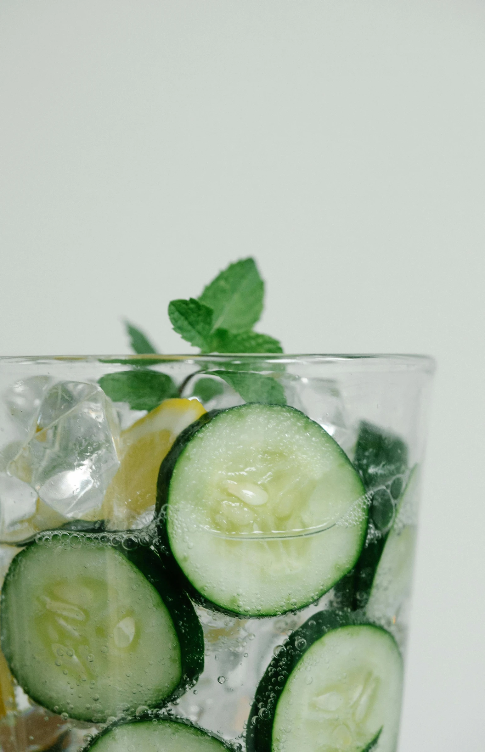 cucumbers and lemons in a glass of water with ice