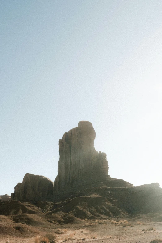 a rock formation with one sitting on top in the desert