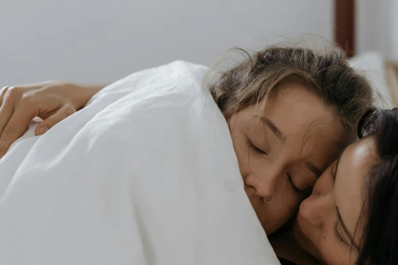 a close up of two people under a blanket