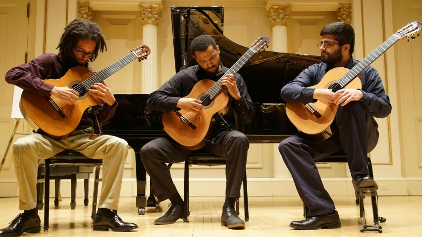 two men play instruments while sitting down