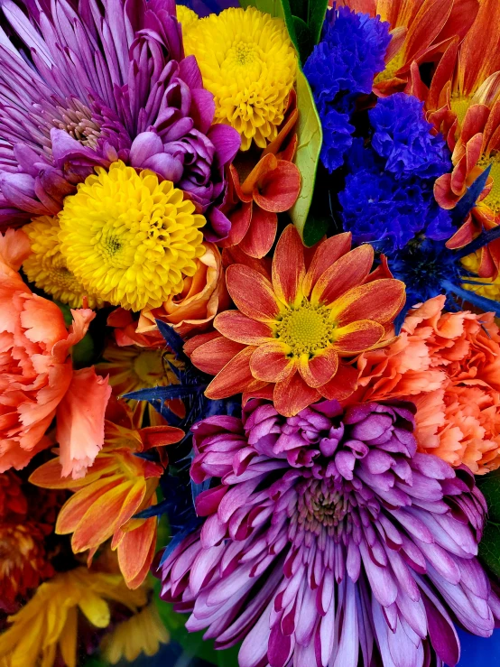 a blue vase filled with different colored flowers