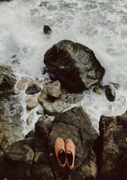 the shoe is on the rocks by the water