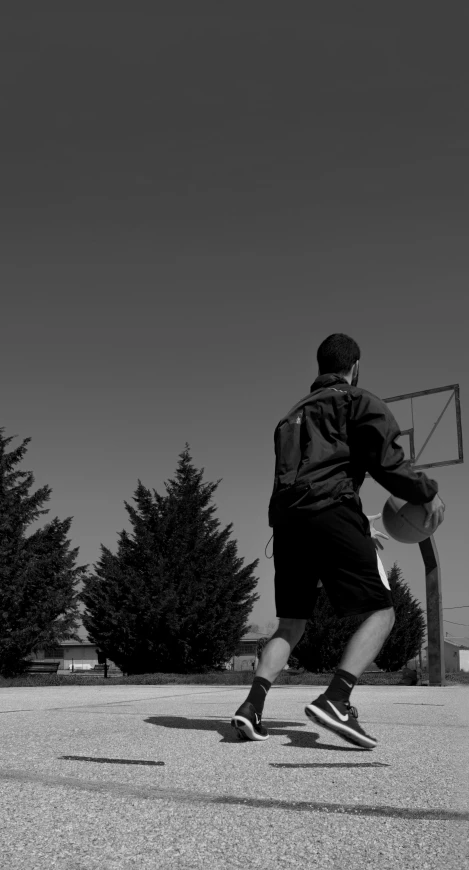 a man standing outside with a basketball hoop on his finger