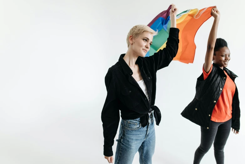 two women posing with a bright colorful scarf