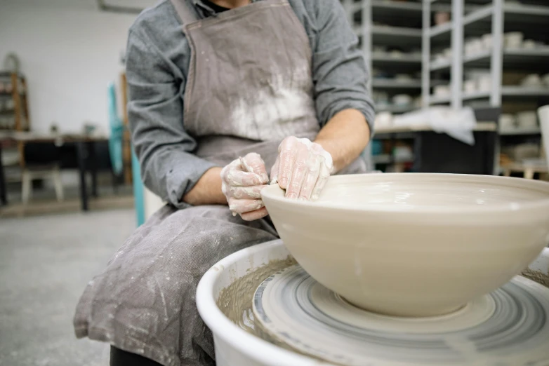 a potter is spinning on a wheel to make a pottery bowl