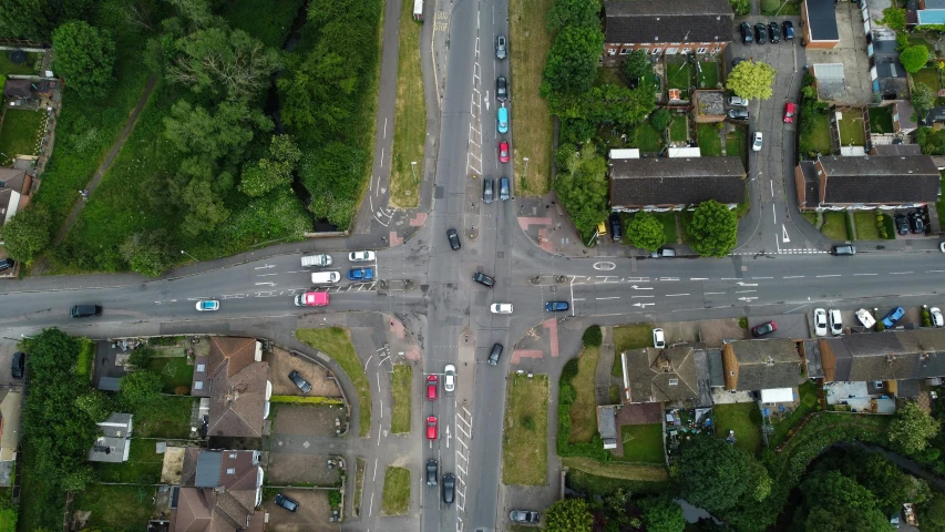 an aerial s of a two way street surrounded by houses