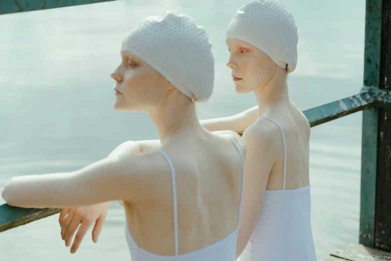 two women are standing outside by the water