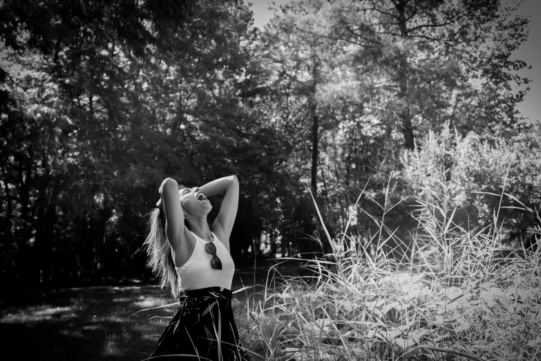 a woman is posing in a field in front of some tall grass