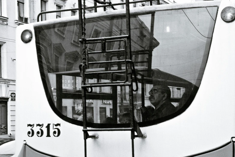 a bus with ladders parked by a building