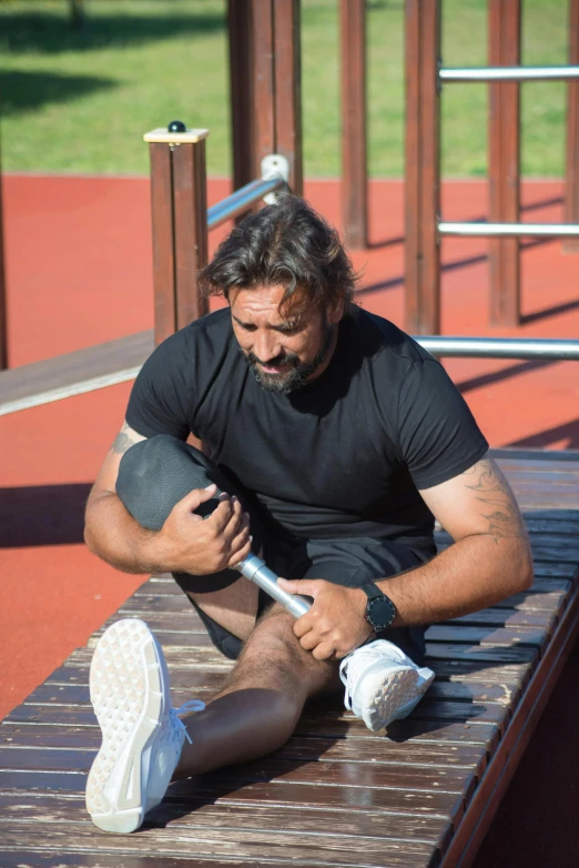 a man sitting on a bench in black t - shirt