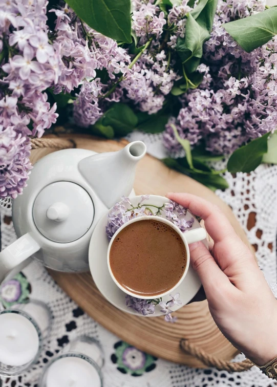 a cup of coffee next to a plate filled with lavenders