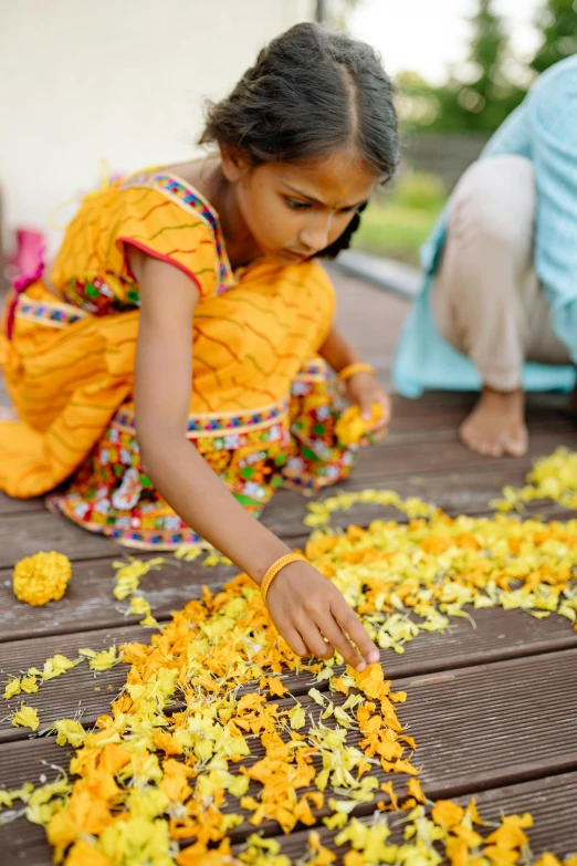 a little girl is sitting down with flowers in the middle