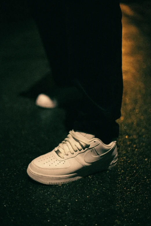 a person standing in a dark room next to some shoes