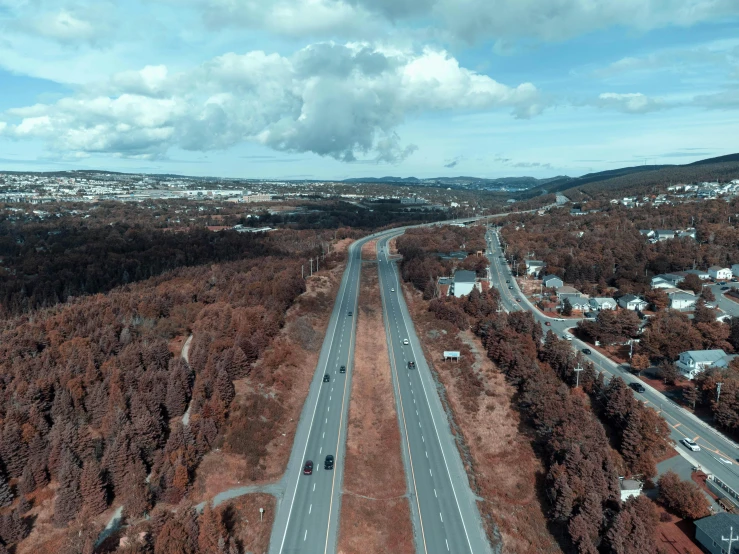 an aerial view of a wide highway that cuts through land