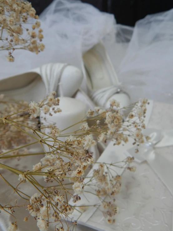 shoes with wedding accessories near flowers on a table