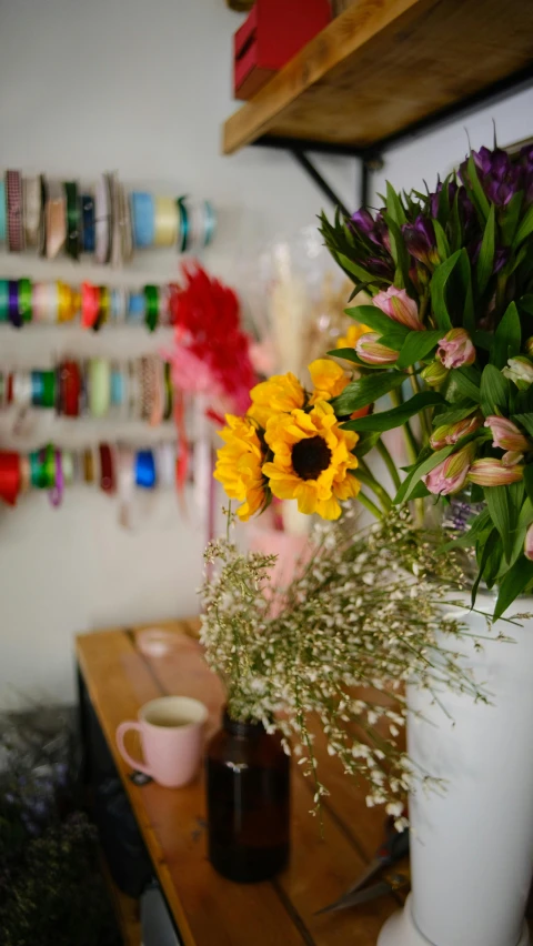 a vase with flowers on the table and some craft supplies