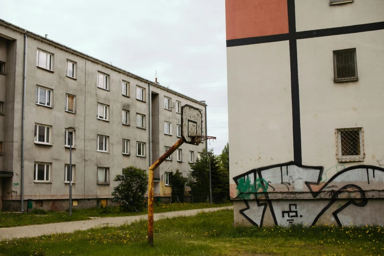 an old basketball hoop in front of a dilapidated apartment building