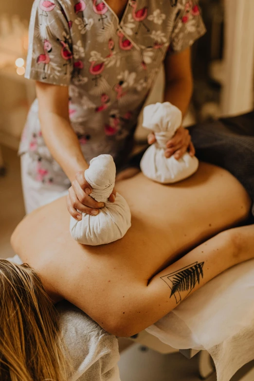 a woman sitting on top of a person on a pillow in a room