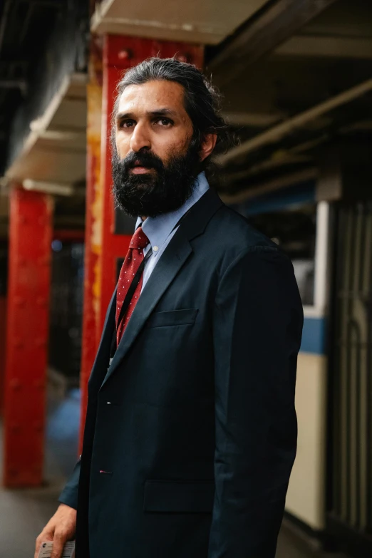 bearded man in suit and tie in subway car