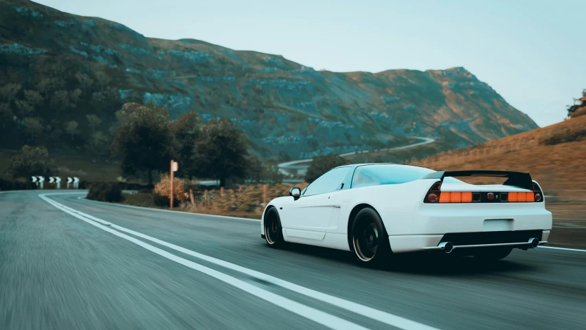 a white car drives down a mountain road