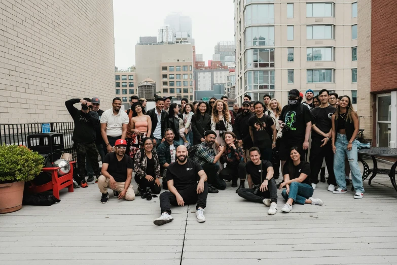 a group of young men in black clothing posing on a rooftop