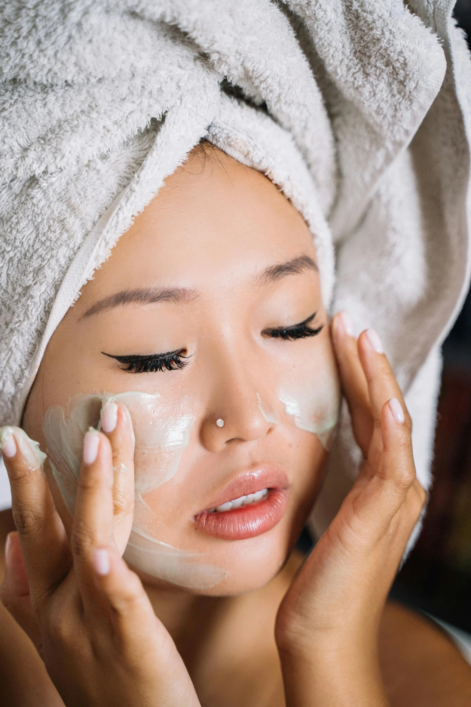 a woman with a towel wrapped around her head on top of a sheet