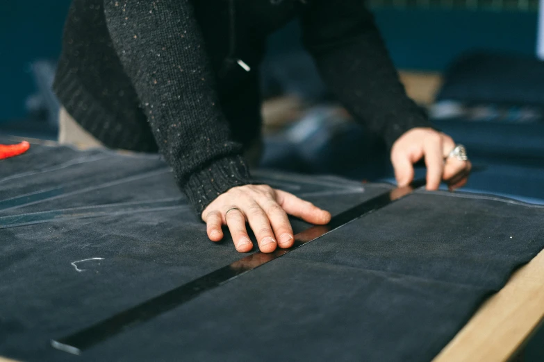 a person is standing over a piece of fabric