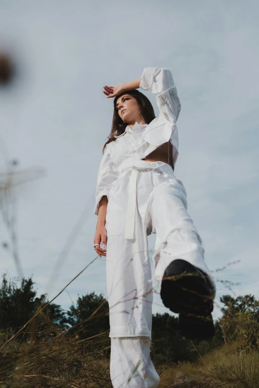 a woman wearing a white top and white pants