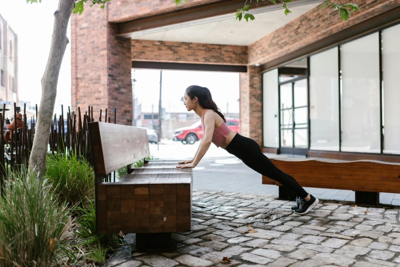 the woman is practicing her yoga posture on the bench