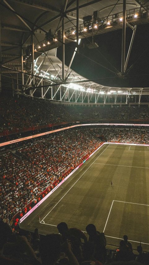 a large crowd is sitting in an empty stadium