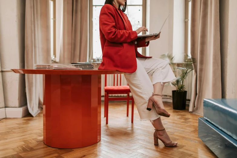 a woman sitting on top of a chair on a laptop computer