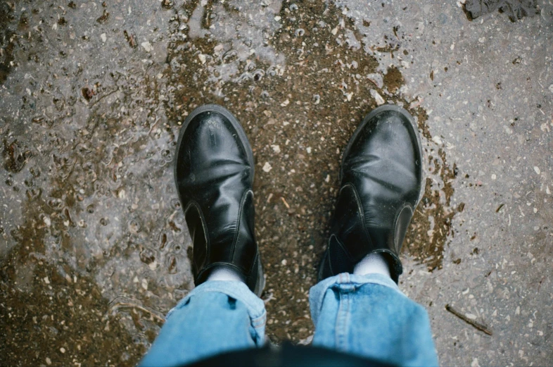 a person is standing up with their feet in the rain