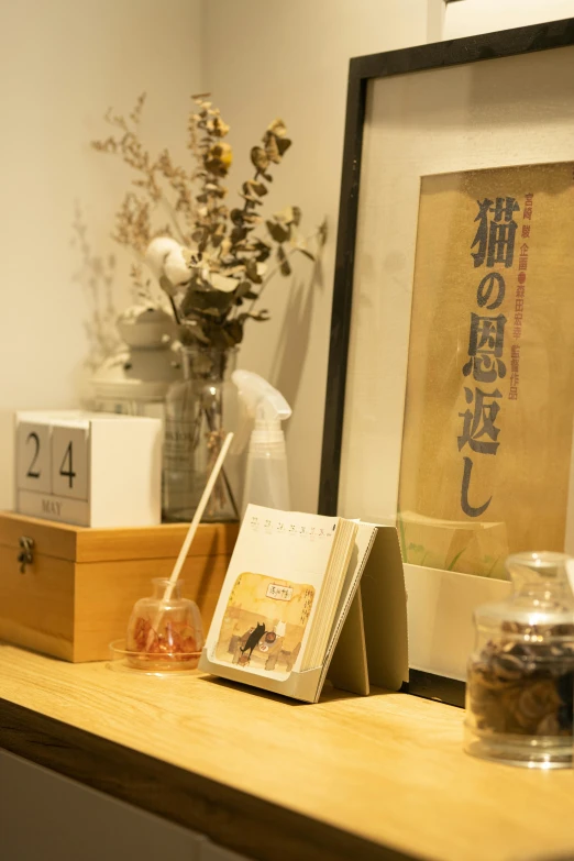 two vases of flowers are on the desk beside a chinese style calendar